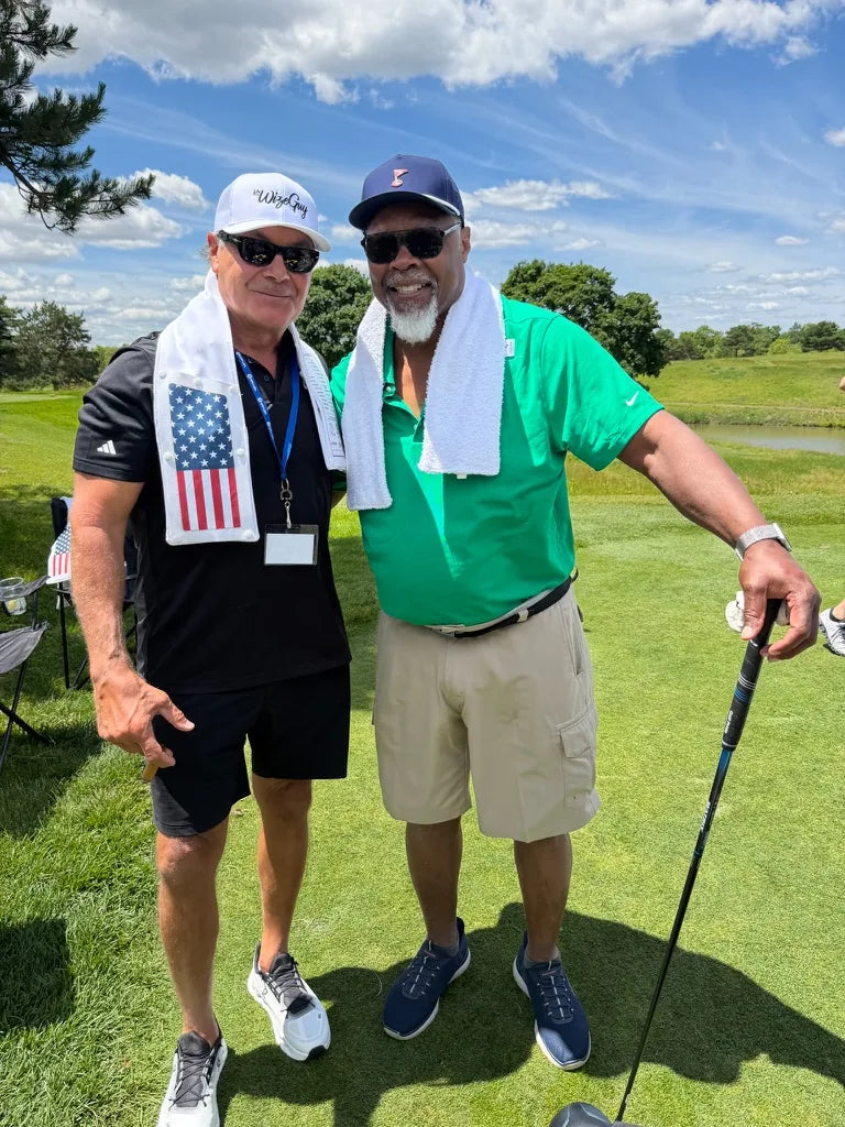 Two golfers on the course wearing LivWizeGuy towels