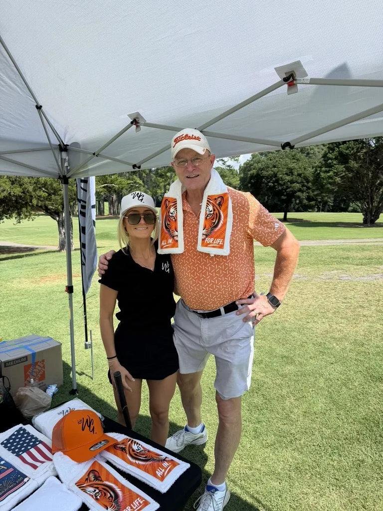A guest in a Tiger towel with a LivWizeGuy team member at the tent