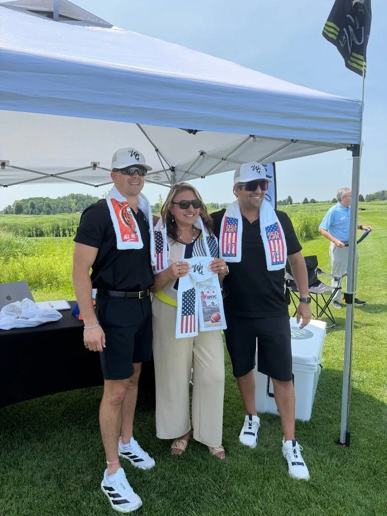 The LivWizeGuy team presenting a towel at their tent on the course