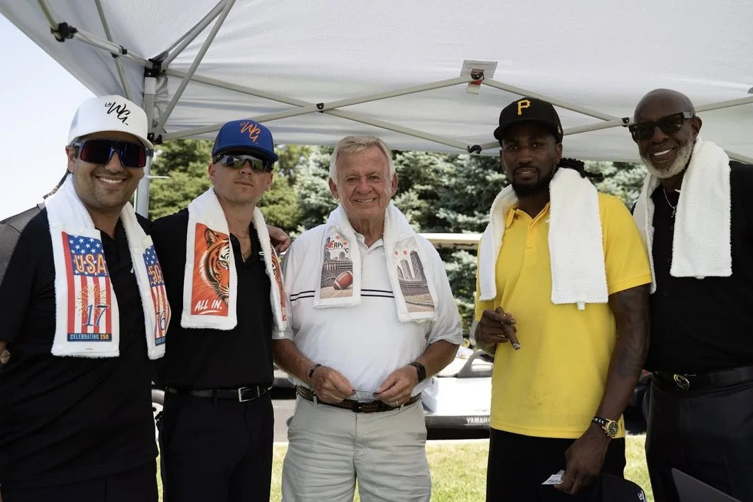 Five golfers under a tent at the Celebrity Golf Outing wearing LivWizeGuy towels