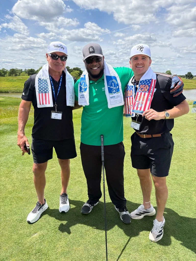 Three golfers on the tee wearing LivWizeGuy Skin towels