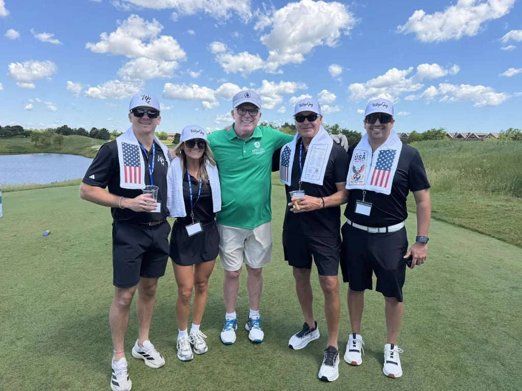 Five golfers on the tee, four wearing LivWizeGuy towels